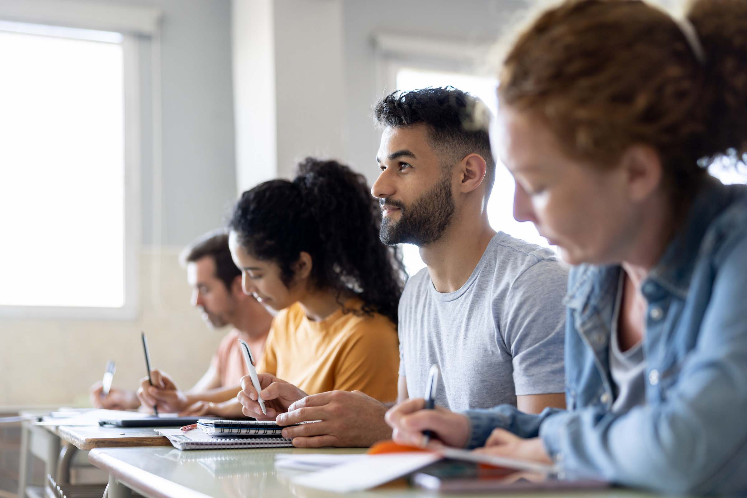 College students taking notes together in class