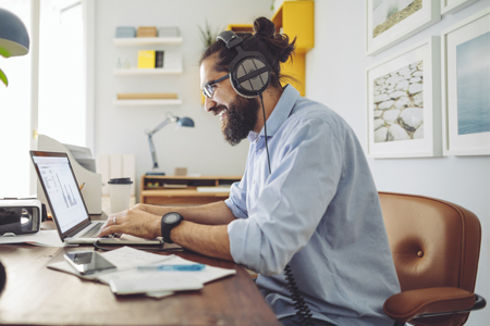 Male health information worker with man bun working from home