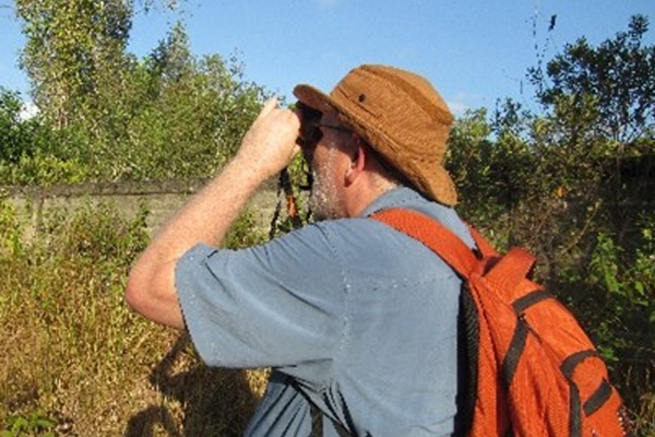 COCC Professor Matthew Novak using binoculars on a hike